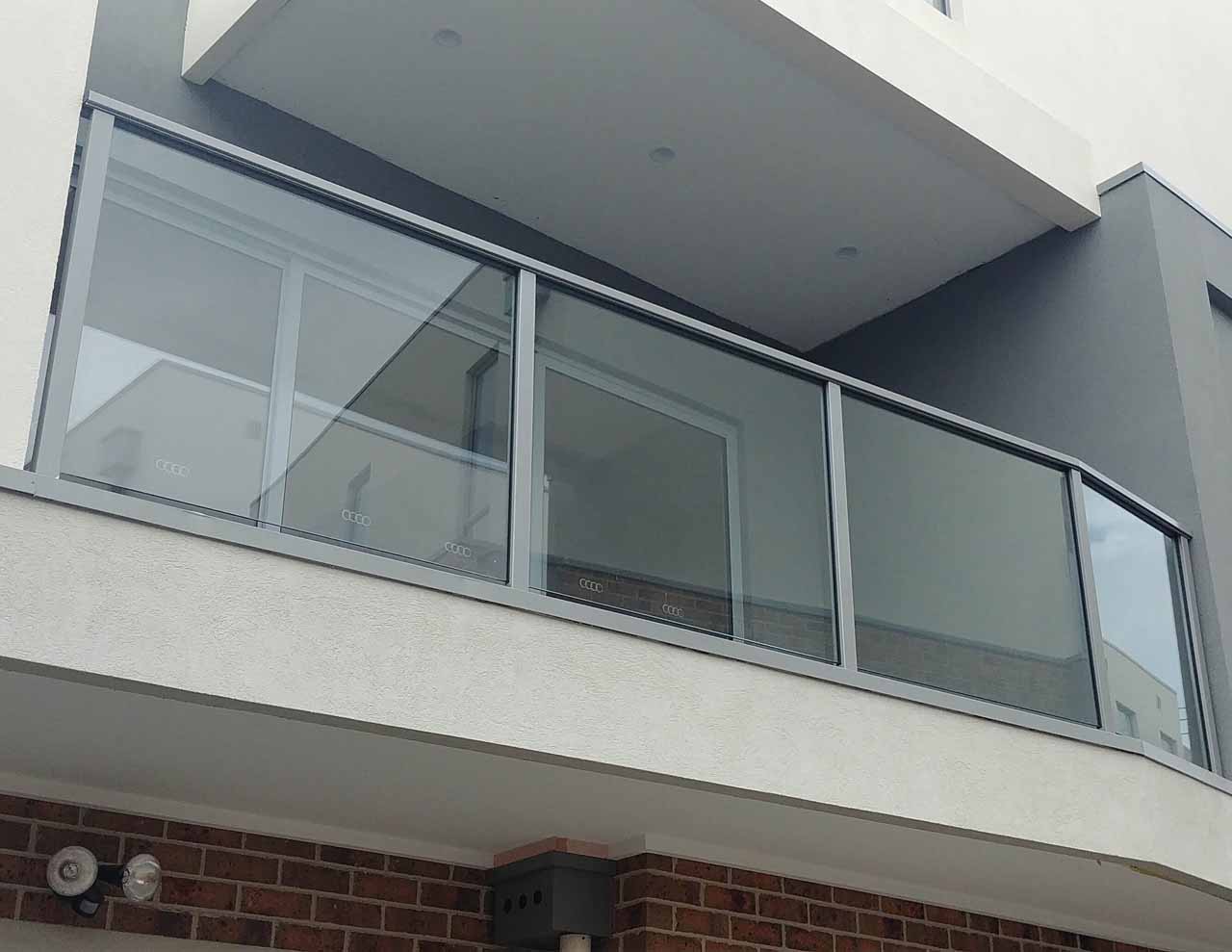 Bottom view of a house balcony having frameless acrylic glass railing